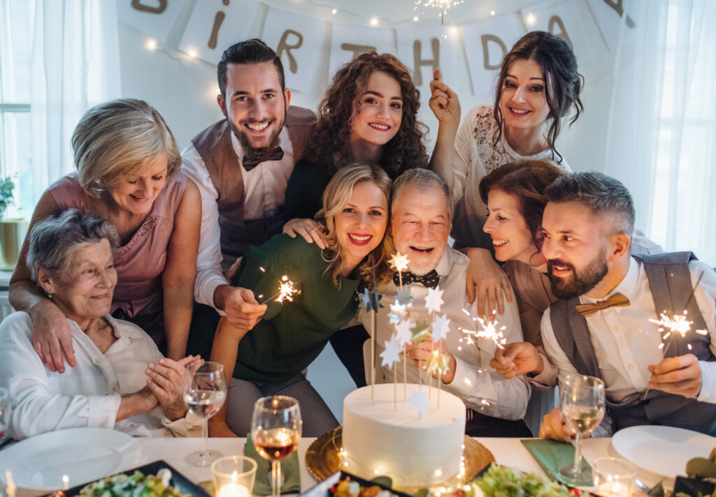 Multigenerational family celebrating a senior relative's birthday with sparklers